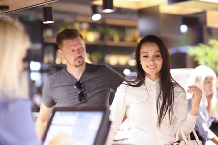 Pensive woman stands near the terminal man looks at her in surprise. Customer service concept
