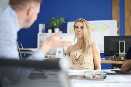Businesswoman in office sits at her desk and listens attentively to her interlocutor. Relationship in the work collective conceptの写真素材