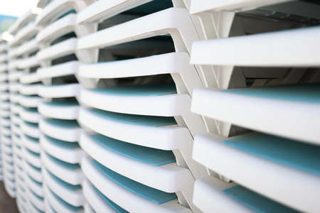 Stack of neatly folded sun loungers. Sun loungers on each other on beach concept.の写真素材