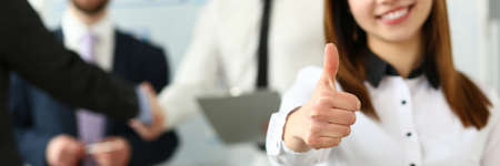 Businesswoman showing a thumbs up gesture in office