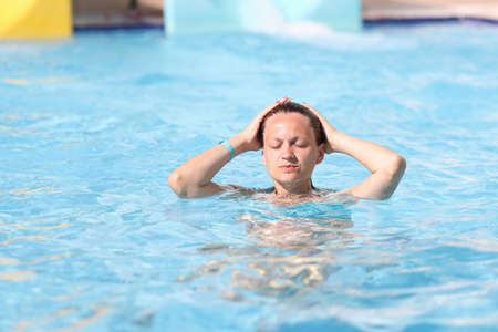 Portrait of woman with closed eyes in water park in pool. Recreation in water parks conceptの写真素材