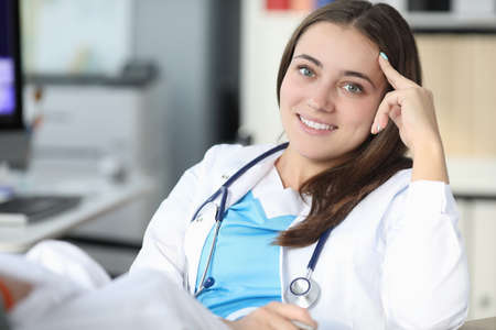 Young beautiful woman doctor with phonendoscope around her neck smiling during break from work portrait. Recreation of medical personnel while working in clinic concept.の写真素材
