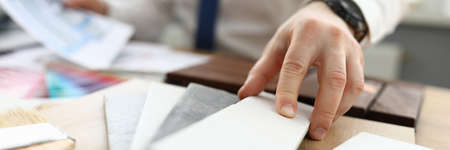 Close-up of designer table with stuff for flat renovation. Samples of tiles for wall and floor....