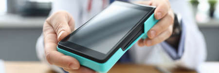Close-up of professional doctor showing device on camera. Medical worker in uniform. Planned check...