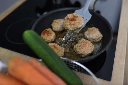Chef uses spatula to flip over fried cutlets in kitchen closeup. Cooking meat dishes concept.の写真素材