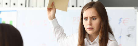 Portrait of smart businesswoman looking at somebody with strange look in gorgeous eyes. Pretty...