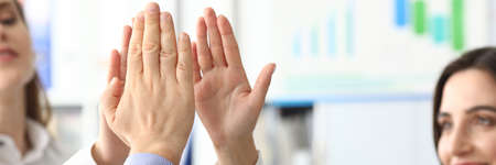 Focus on female and male hands demonstrating greeting gesture and posing at modern workplace....