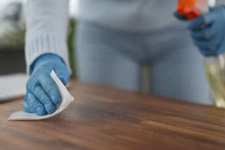 Woman wipes table from dirt. Services and maintenance of cleaning companies concept