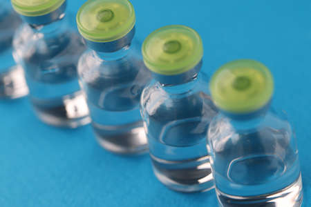Transparent medical small bottles on blue background. Medical injection concept
