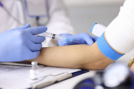 Doctor injecting medication into patients ulnar vein at clinic closeup. Emergency care concept