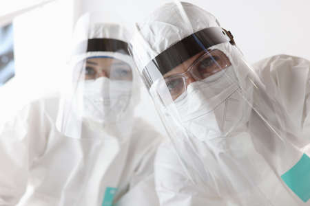 Bottom view of doctors in anti-plague protective suits and screens at hospital. Covid-19 treatment conceptの写真素材