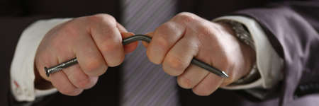 Angry businessman deforming metal thing while expressing his unsatisfaction after meeting with partnersの写真素材