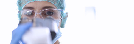 Laboratory assistant look through microscope. Close-up portrait of doctor.