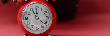 Red arrow clock at midnight stands behind New Year tree. Coming New Year and Christmas conceptの写真素材