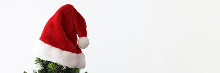 At top of New Year tree hanging santa clauss red hat close-up. Christmas eve conceptの写真素材