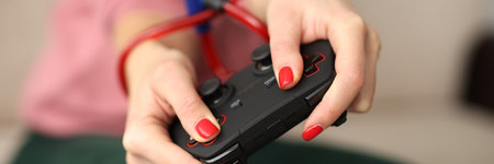 Young woman holding in hands tied with rope joystick from video games computer close-up. Mental...