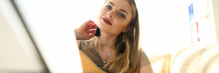 Charming lady guitarist looking at camera and smiling while holding acoustic musical instrument