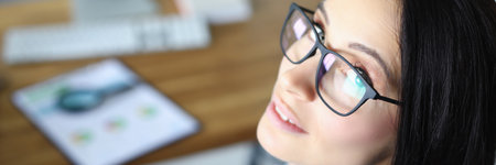 Top view of businesswoman looking at camera with interest and gladness. Businesslady writing...