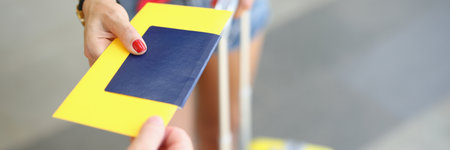 Female male hand hold passport and ticket on background of suitcase. Travel around the world conceptの写真素材