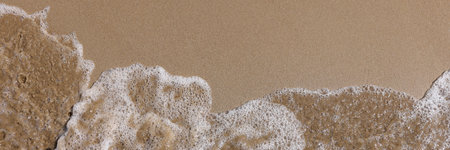 Sea wave washes sandy shore of beach background. Vacation at sea concept.の写真素材