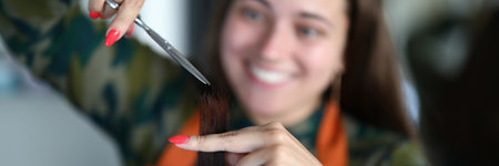 Hairdresser with manicure cuts female hair. Permanent procedure for basic hair care. Creating a stylish lookの写真素材