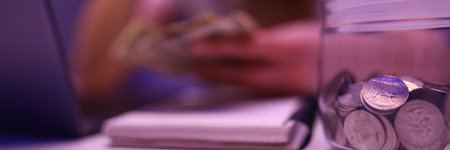 An upset woman leaned over the money. Revision of the family budget after job lossの写真素材