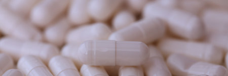 Close up of white pills capsules. Pharmaceutical industry concept