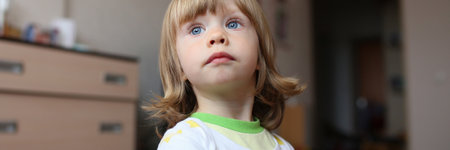 Happy kid wearing pajamas and looking away while just waking up in the morning in his nursery