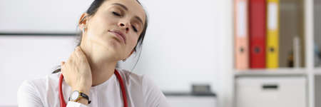 Tired doctor in office after working day. Medical fatigue in pandemic conceptの写真素材