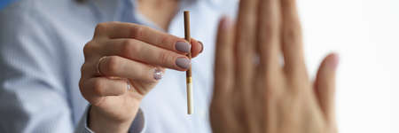 Woman offers cigarette to man who makes negative gesture. The harm of smoking on the human body conceptの写真素材