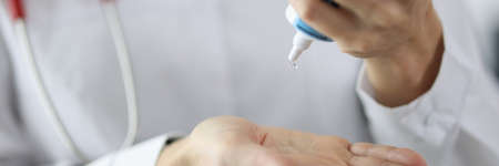 Doctor squeezes gel from tube onto hand. Medical ultrasound gel concept