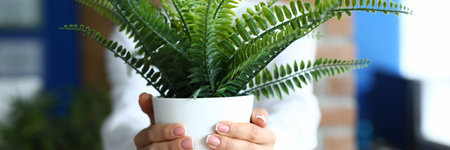 Woman holds flowerpot with flowers in her hands. Concept home gardening online storeの写真素材