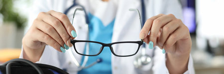 Doctor with stethoscope and apparatus for changing pressure with glasses in his hands in office...