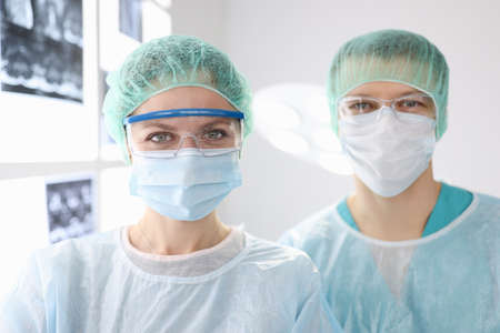 Portraits of doctors surgeons in protective clothing in clinic. Surgical care conceptの写真素材