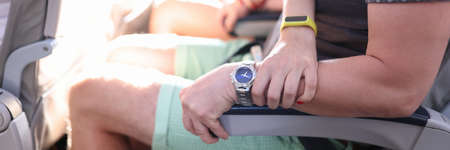 Man sit in seat on airplane. Woman hand squeezes man hand in fear on plane.の写真素材