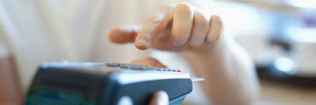 Man holds terminal with a plastic card in his hand. Safe payments conceptの写真素材