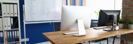 An office in which desk is computers white information board and cabinet with documents. Workspace planning in office conceptの写真素材