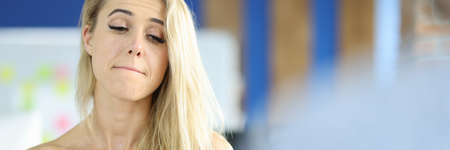 Woman in office with a sad face and eyes listens to interlocutor. Reduction of personnel in organizations conceptの写真素材