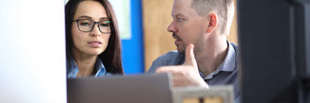 Man and woman discuss in office at workplace IT tehonology at computer.の写真素材