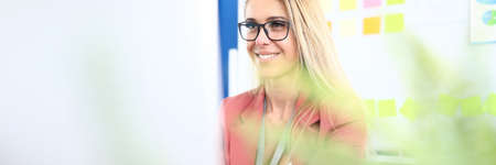 Businesswoman in glasses work at computer at workplace and smile.