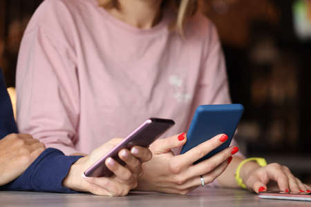 Two people are holding smartphones in their hands closeupの写真素材