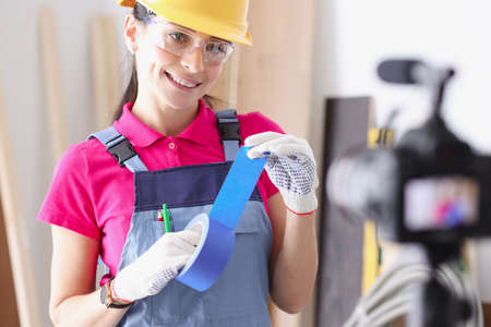 Builder blogger demonstrates blue duct tape for repairs on camera