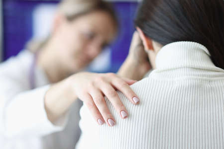 Physician holds upset patient shoulder sympathetically closeupの写真素材