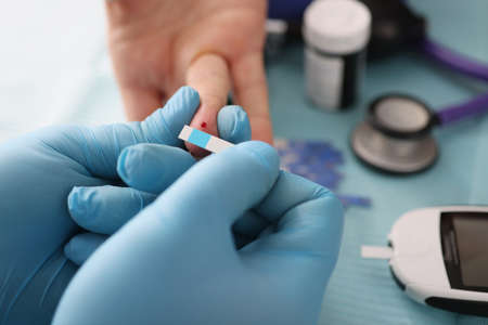 Doctor draws blood for aglucose test closeupの写真素材