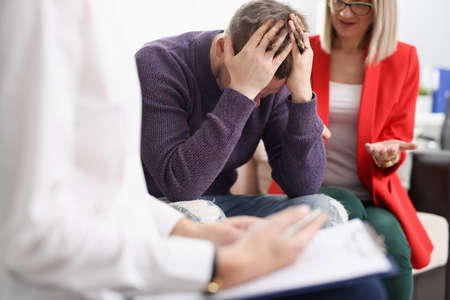 Upset man with woman at psychotherapist appointmentの写真素材