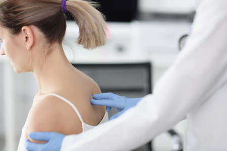 Doctor examines patient spine in medical office