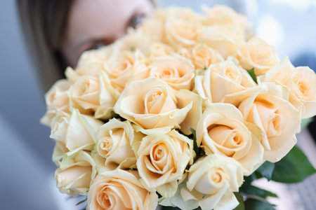 Woman holding large beautiful bouquet of white roses closeupの写真素材