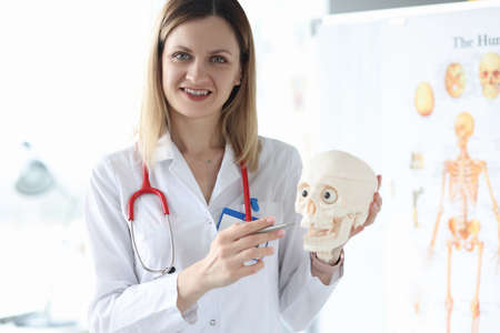 Smiling portrait medic holds human skull closeupの写真素材
