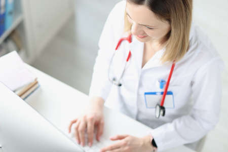 Doctor is typing on keyboard at desktop