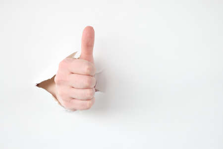 Female hand makes thumbs up gesture closeupの写真素材